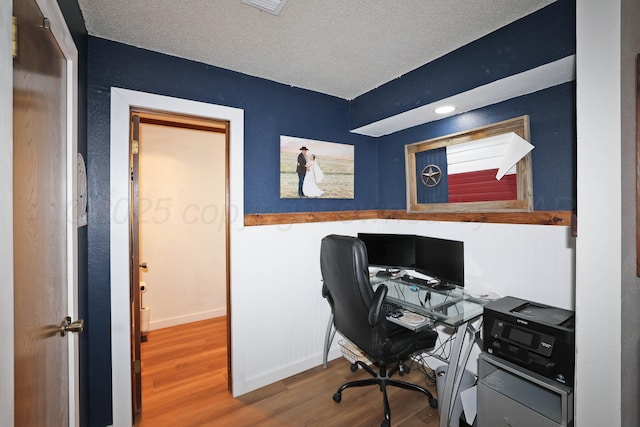 315 Walnut Ave, Panhandle, TX 79068 - home office featuring wood finished floors, a textured ceiling, and a wainscoted wall