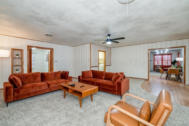 living area featuring a ceiling fan, visible vents, and wood finished floors