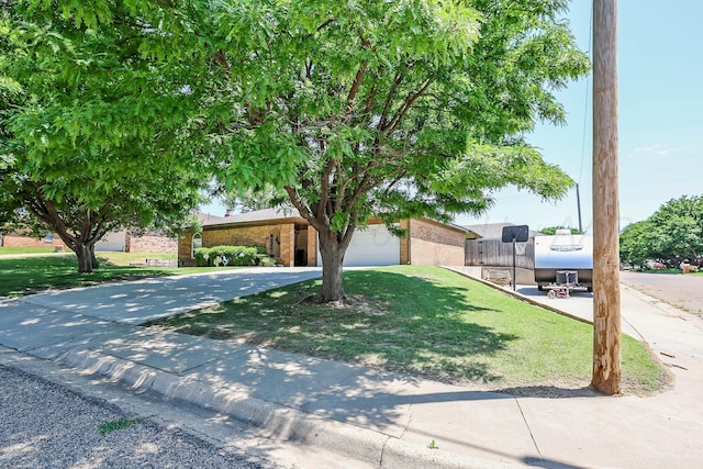 6728 Arroyo Dr, Amarillo, TX 79108 - view of property hidden behind natural elements featuring brick siding, driveway, an attached garage, and a front yard
