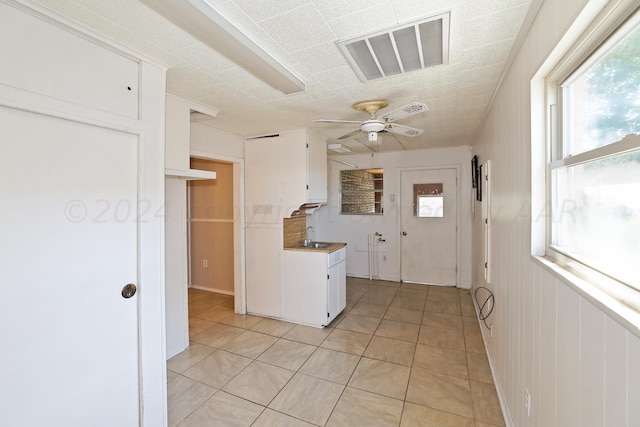 1307 Cooley Dr, Borger, TX 79007 - kitchen with healthy amount of natural light, white cabinetry, and a ceiling fan