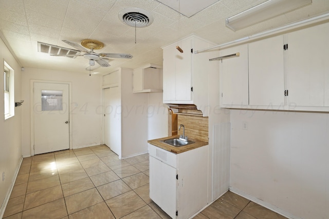 1307 Cooley Dr, Borger, TX 79007 - kitchen with a sink, a ceiling fan, light tile patterned floors, and white cabinets
