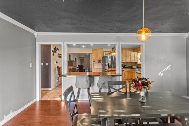 dining room with wood-type flooring and ornamental molding