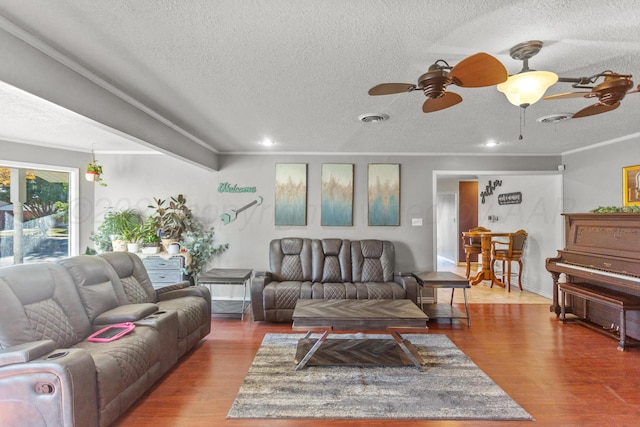 living room featuring a textured ceiling, hardwood / wood-style flooring, and ceiling fan