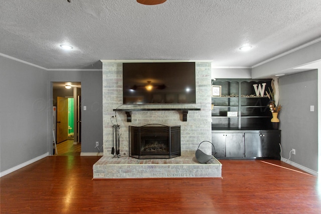 unfurnished living room featuring dark hardwood / wood-style flooring, a textured ceiling, crown molding, and a fireplace