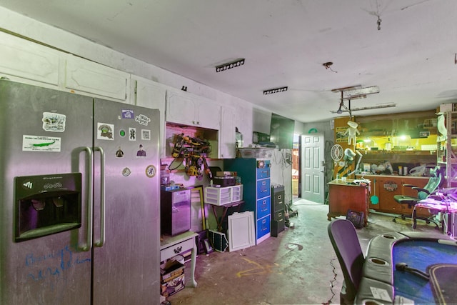 kitchen with white cabinetry, concrete flooring, decorative light fixtures, and stainless steel fridge with ice dispenser