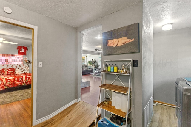 hall featuring wood-type flooring and a textured ceiling