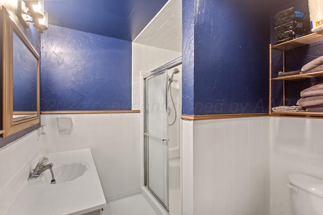 bathroom featuring vanity, toilet, and a shower with shower door