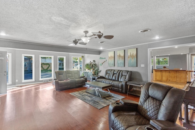 living room featuring hardwood / wood-style floors, a textured ceiling, and ceiling fan