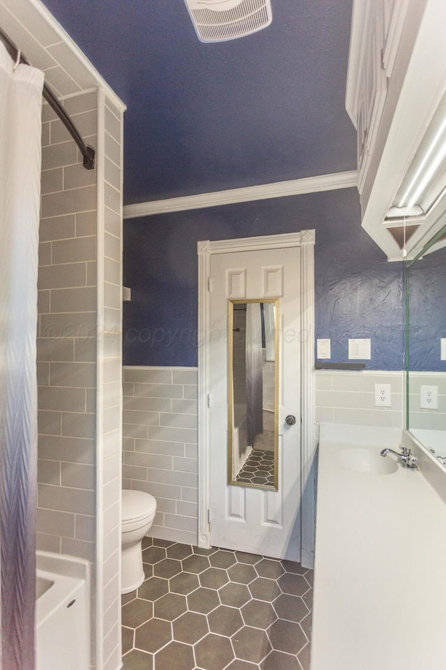 full bathroom with tile walls, vanity, shower / tub combo, tile patterned flooring, and toilet