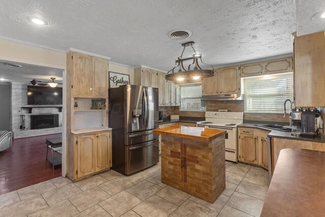 kitchen with ceiling fan, a kitchen island, stainless steel fridge, pendant lighting, and electric range