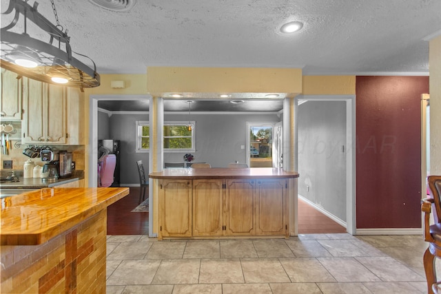 kitchen featuring a textured ceiling, crown molding, and light tile patterned floors