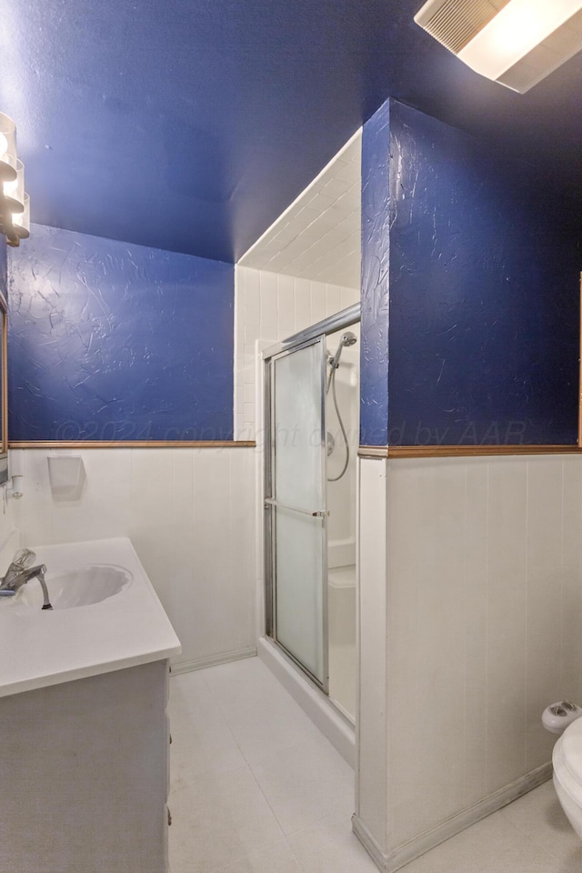 bathroom with toilet, vanity, and an enclosed shower