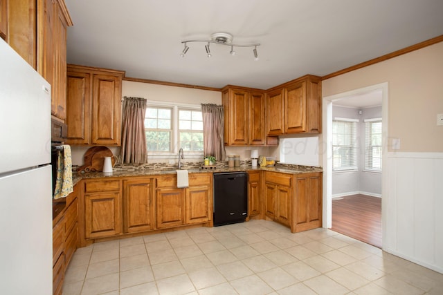 4417 Andrews Ave, Amarillo, TX 79106 - kitchen featuring black dishwasher, freestanding refrigerator, stone counters, brown cabinets, and healthy amount of natural light