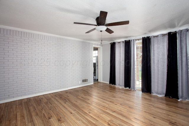 4417 Andrews Ave, Amarillo, TX 79106 - unfurnished room with brick wall, a ceiling fan, wood finished floors, and ornamental molding