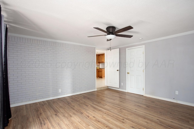 4417 Andrews Ave, Amarillo, TX 79106 - empty room with brick wall, ceiling fan, wood finished floors, and ornamental molding
