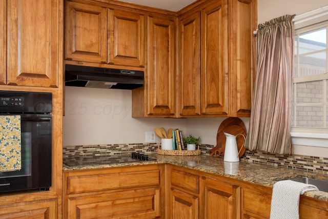 4417 Andrews Ave, Amarillo, TX 79106 - kitchen featuring black appliances, under cabinet range hood, tasteful backsplash, and brown cabinetry