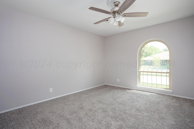 carpeted spare room featuring ceiling fan