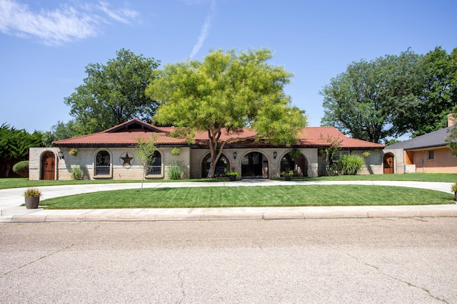 mediterranean / spanish-style house featuring a front lawn