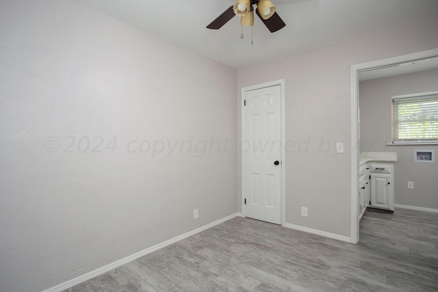 unfurnished bedroom with ceiling fan and light hardwood / wood-style flooring