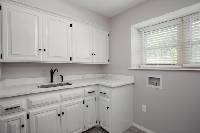 washroom featuring hookup for a washing machine, sink, and cabinets