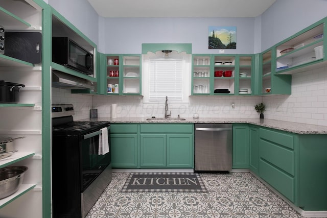 kitchen featuring light stone counters, sink, green cabinets, and appliances with stainless steel finishes