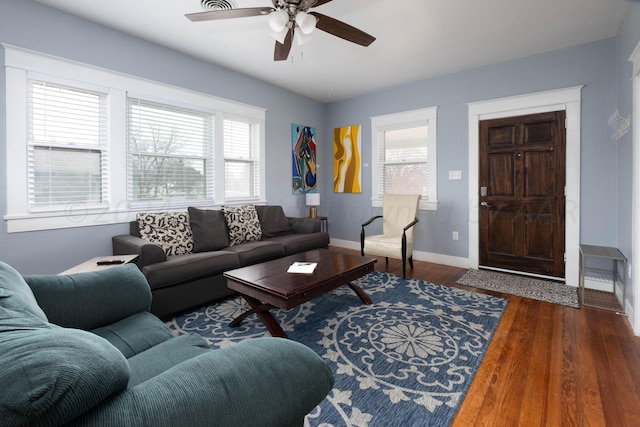 living room featuring a wealth of natural light, dark wood-type flooring, and ceiling fan