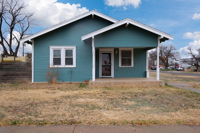 bungalow-style house with a porch and a front lawn