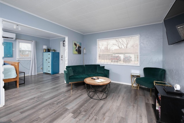 living area with wood-type flooring, ornamental molding, and a wall mounted air conditioner