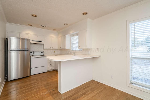 212 S Timbercreek Dr, Amarillo, TX 79118 - kitchen with freestanding refrigerator, white range with electric stovetop, under cabinet range hood, ornamental molding, and a peninsula