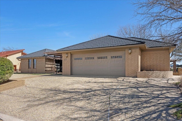 view of front of home with a garage, brick siding, and driveway