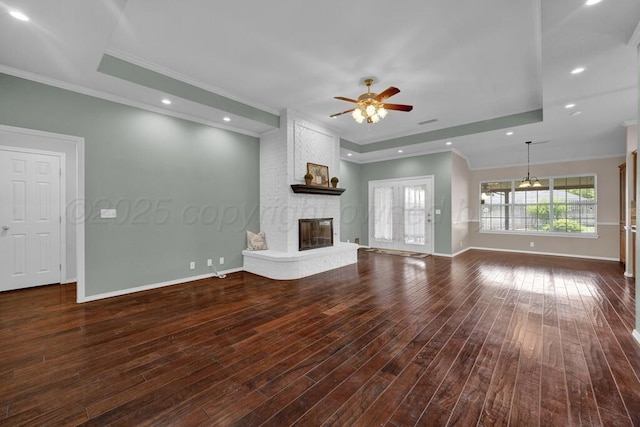 6611 Admiral Ct, Amarillo, TX 79124 - unfurnished living room with ornamental molding, a ceiling fan, a fireplace, a tray ceiling, and dark wood finished floors