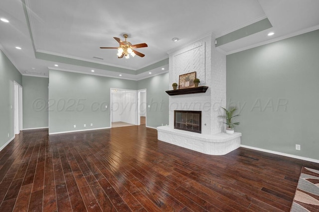 6611 Admiral Ct, Amarillo, TX 79124 - unfurnished living room featuring a tray ceiling, ceiling fan, ornamental molding, a fireplace, and wood finished floors