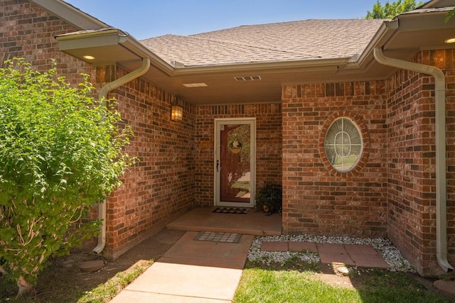 6611 Admiral Ct, Amarillo, TX 79124 - doorway to property featuring roof with shingles and brick siding