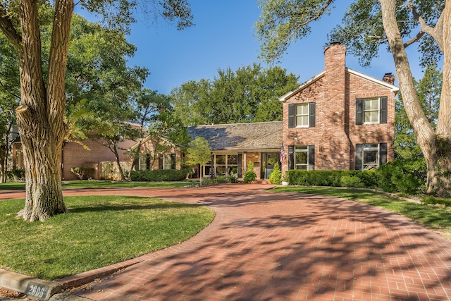 2606 S Lipscomb St, Amarillo, TX 79109 - view of front of home featuring brick siding, curved driveway, a chimney, and a front lawn