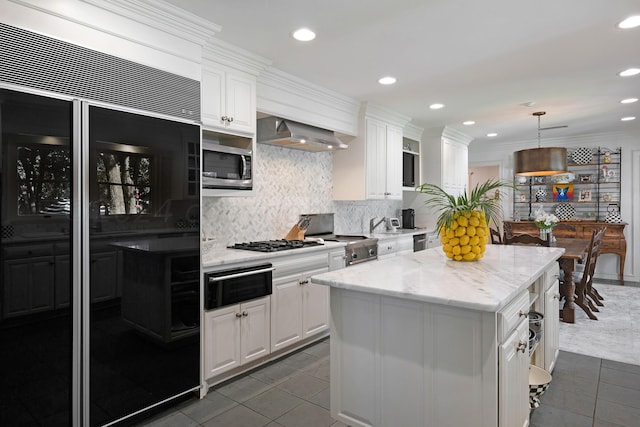 2606 S Lipscomb St, Amarillo, TX 79109 - kitchen with a center island, white cabinets, hanging light fixtures, ornamental molding, and stainless steel appliances