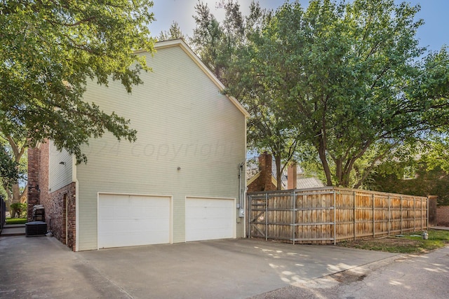 2606 S Lipscomb St, Amarillo, TX 79109 - view of side of home with a garage, concrete driveway, brick siding, and central air condition unit