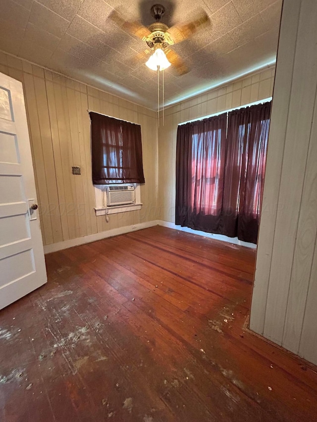 spare room with cooling unit, hardwood / wood-style floors, baseboards, and a ceiling fan