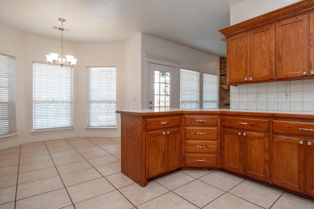 6203 Donda St, Amarillo, TX 79118 - kitchen featuring brown cabinets, light tile patterned flooring, plenty of natural light, and a chandelier