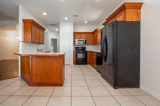 6203 Donda St, Amarillo, TX 79118 - kitchen featuring black appliances, a peninsula, backsplash, brown cabinets, and light tile patterned floors