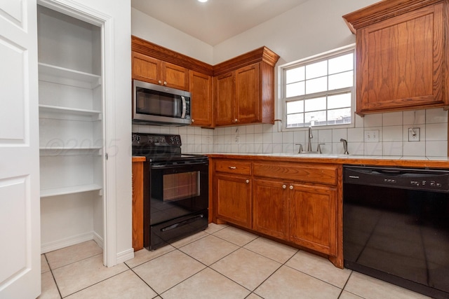6203 Donda St, Amarillo, TX 79118 - kitchen with black appliances, tasteful backsplash, brown cabinetry, and light tile patterned flooring