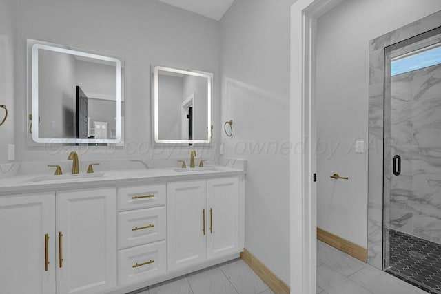 full bathroom with double vanity, marble finish floor, a marble finish shower, and a sink