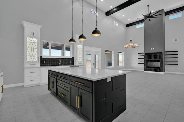 kitchen with marble finish floor, white cabinets, dark cabinets, and a tile fireplace