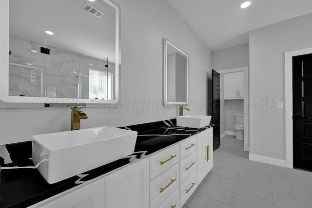 full bathroom with a marble finish shower, visible vents, toilet, marble finish floor, and a sink