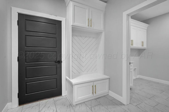 mudroom featuring marble finish floor and baseboards