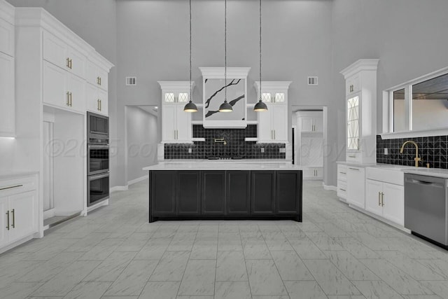 kitchen with a center island, marble finish floor, stainless steel appliances, light countertops, and white cabinets