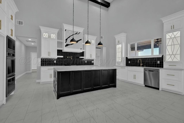 kitchen with white cabinets, light countertops, a kitchen island, and stainless steel dishwasher