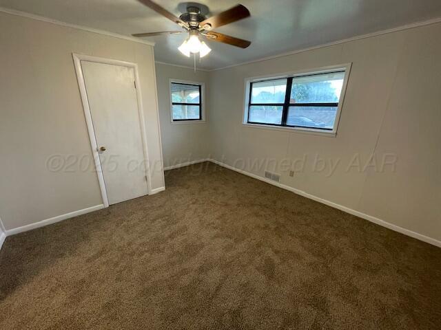 1805 N Jefferson St, Amarillo, TX 79107 - unfurnished bedroom with dark colored carpet, ornamental molding, and ceiling fan