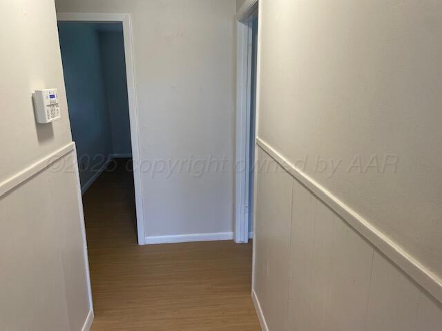 1805 N Jefferson St, Amarillo, TX 79107 - hallway with light wood-type flooring, a decorative wall, and wainscoting