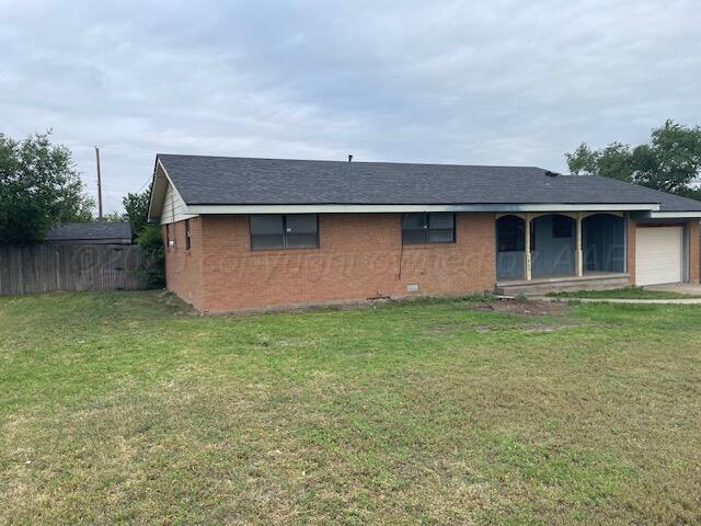 1805 N Jefferson St, Amarillo, TX 79107 - view of front of property featuring an attached garage, brick siding, and a shingled roof