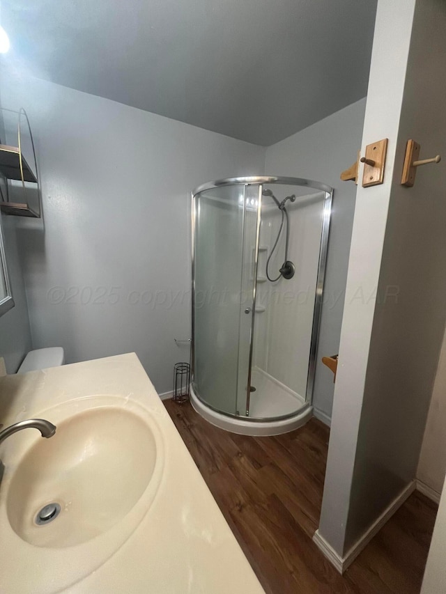 1565 Bell St, Amarillo, TX 79106 - full bathroom featuring wood finished floors, a shower stall, toilet, vanity, and baseboards